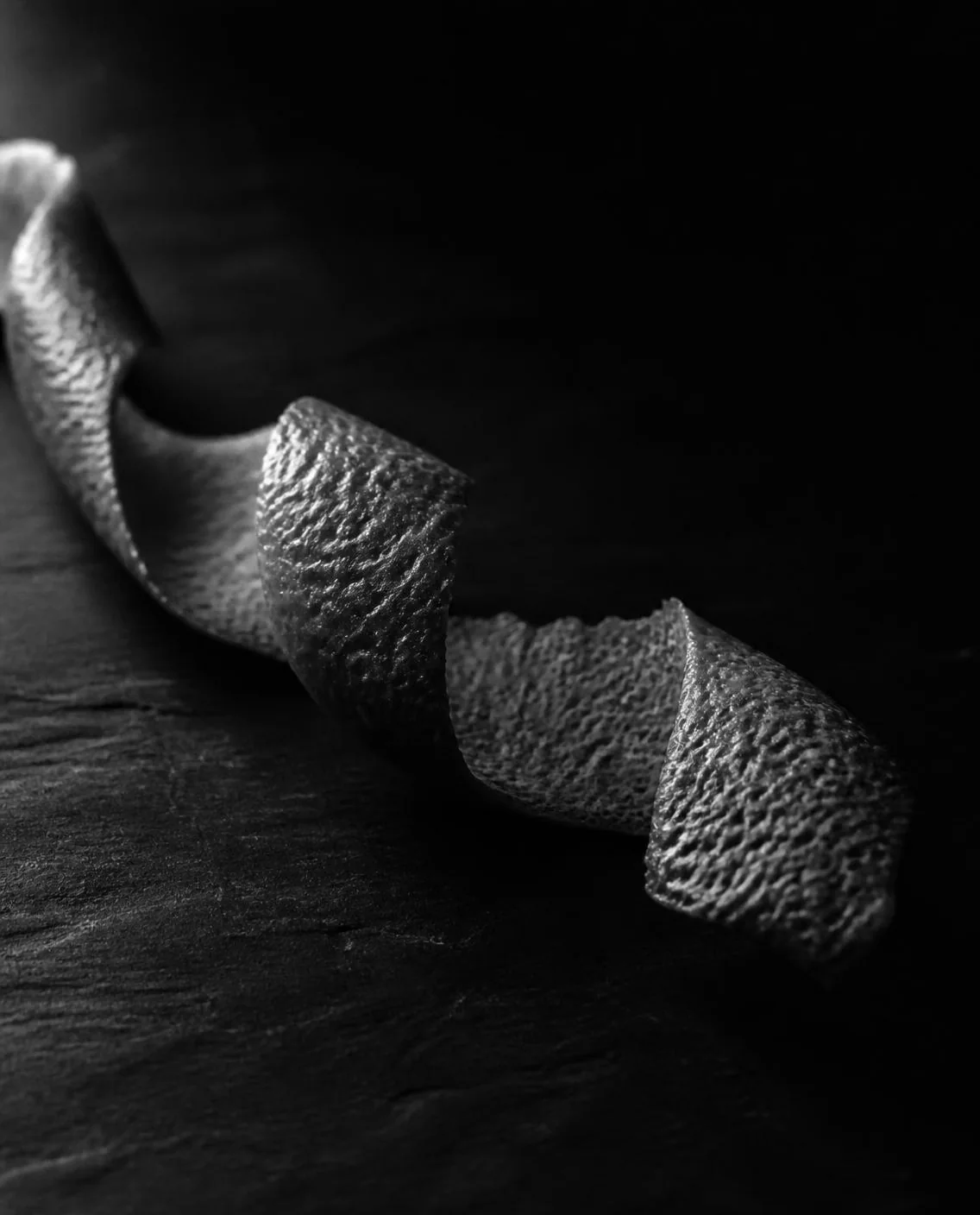 A twist of grapefruit peel in raking light