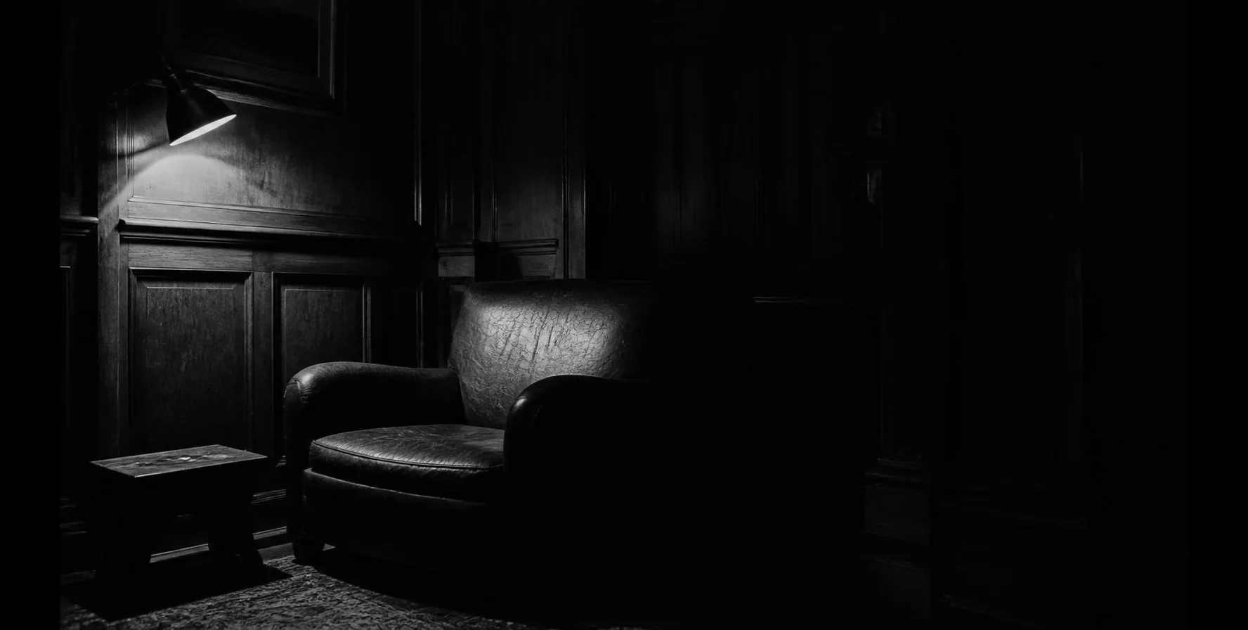 A dark wood-panelled room at night, lit by one lamp