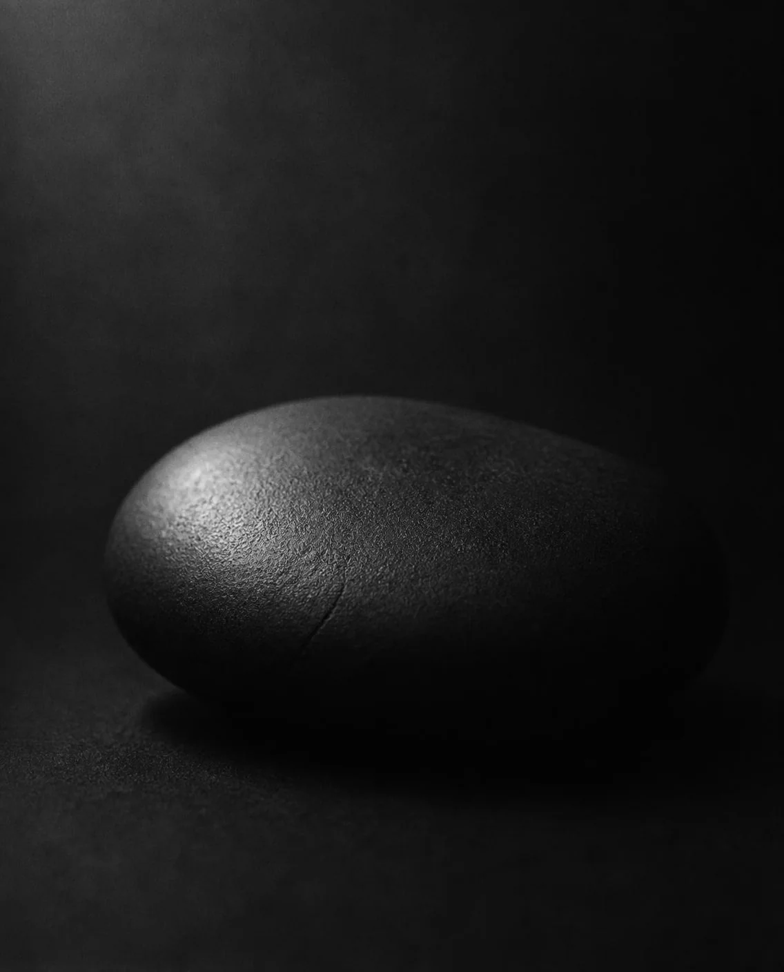 A smooth dark stone with one soft highlight